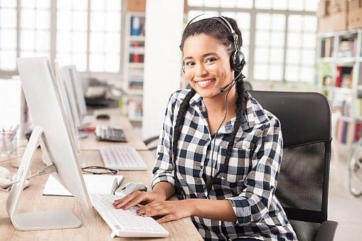 Smiling young female call center worker with headphones